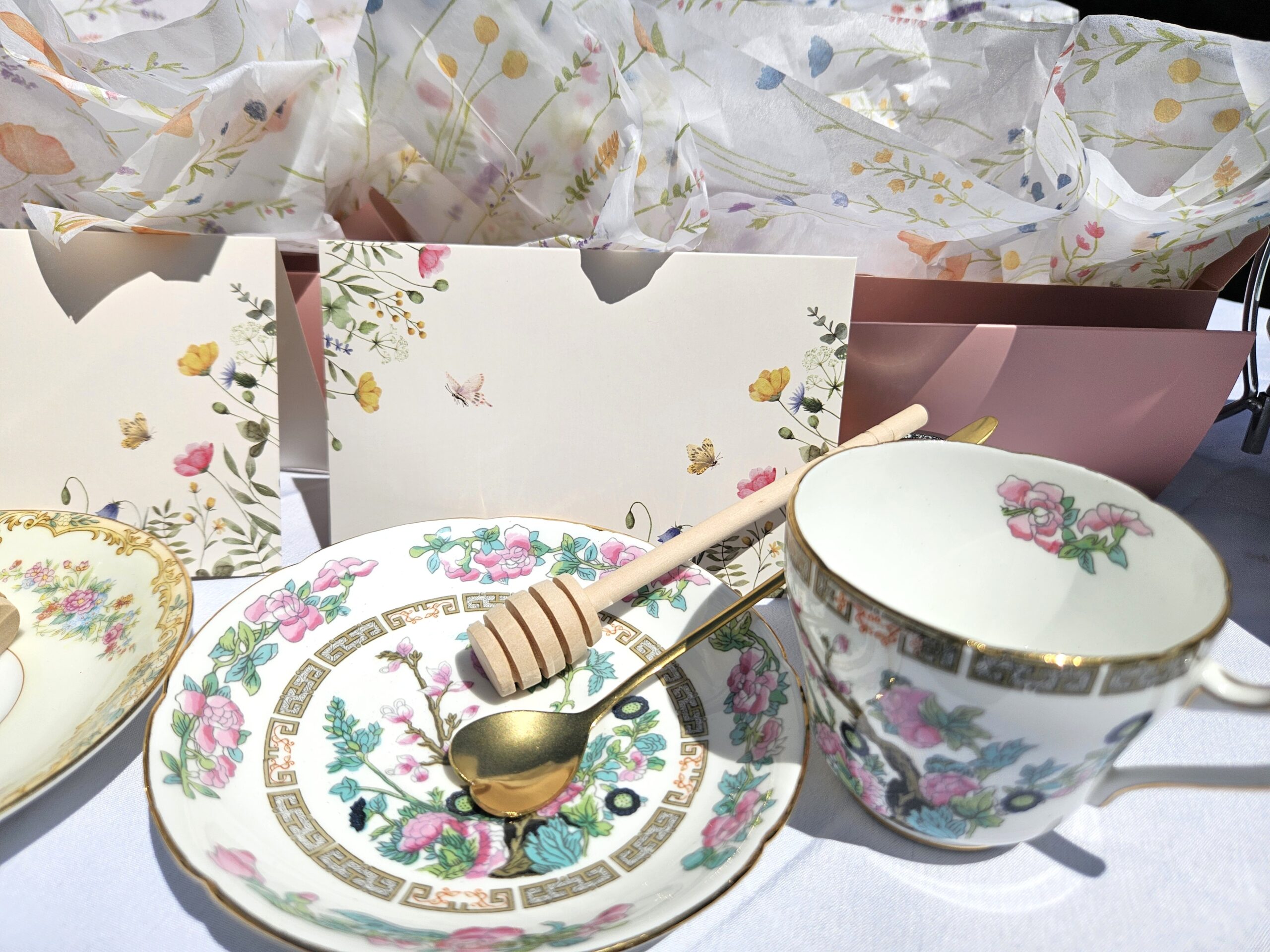 Tea Box open with tea cup, saucer, and honey comb on a table.